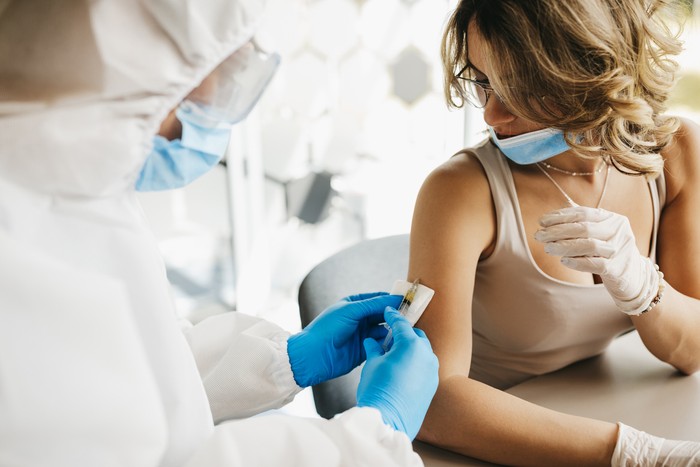 The doctor gives the vaccine against covid19 virus to a female patient
