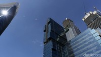 Gedung-gedung pencakar langit berpayung langit biru.