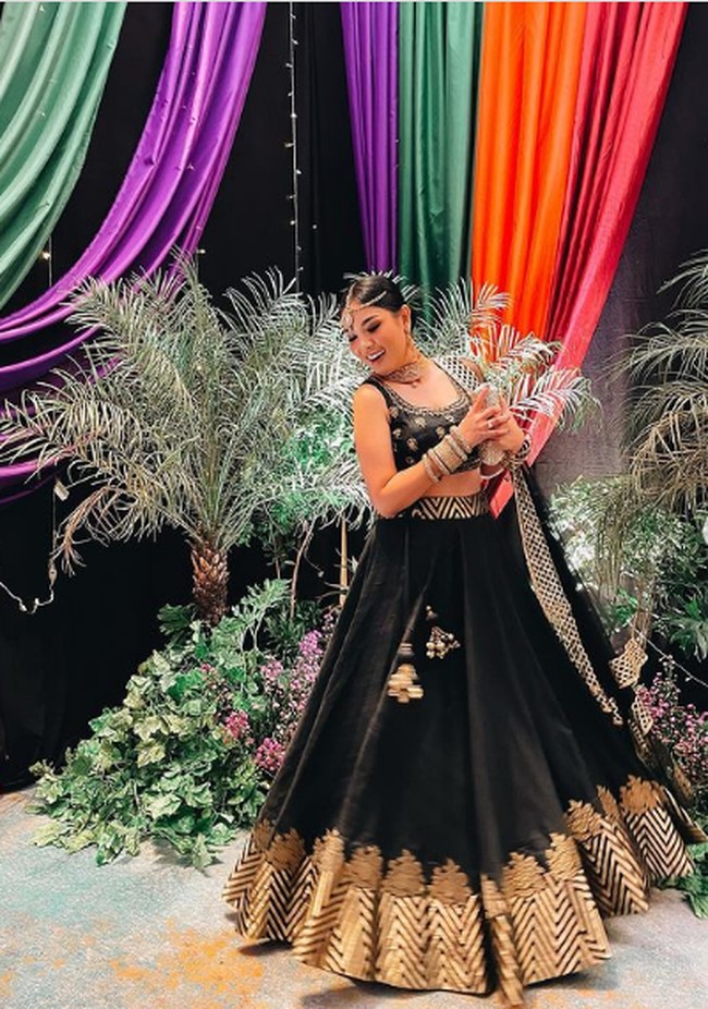 Nindy Ayunda pun tak kalah tampil glmor. Ia mengenakan atasan crop top dan rok bervolume nuansa hitam-emas. Tak lupa aksesori kepala, bangles dan selendang sebagai pelengkap penampilan. Foto: Instagram/@nindyparasadyharsono