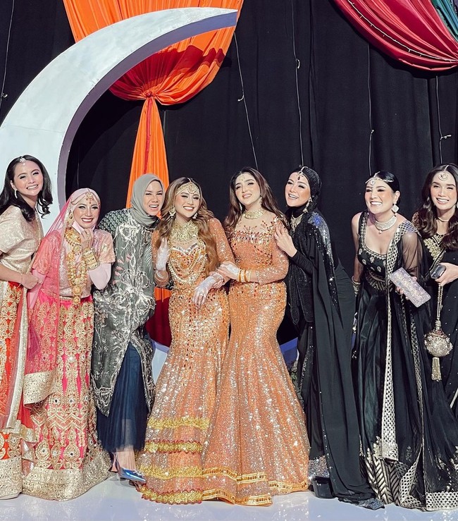 Saat Henna Night, Ashanty dan Aurel bak pinang dibelah dua. Keduanya kembaran mengenakan gaun oranye berpotongan mermaid dan rambut ditata bergelombang. Foto: Instagram