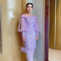Saat prosesi lamaran Atta Halilintar dan Aurel Hermansyah, Ashanty mengenakan kebaya modern warna lilac rancangan Ancha Wedding. Kebaya berpotongan kerah sabrina itu dihiasi tebaran payet dan dipadukan dengan kain songket warna senada. Foto: Instagram/@ashanty_ash