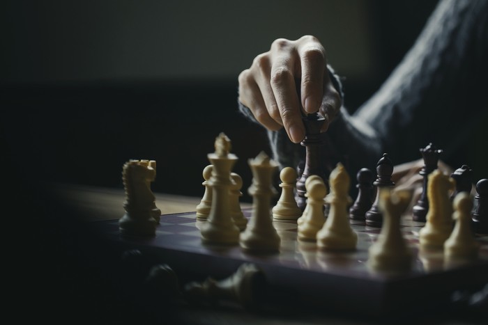 Close up shot hand of young woman playing chess for business challenge competition winner concept