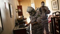 Tercio dan istrinya mengenakan pakaian seperti astronot lengkap dengan helm dan masker.