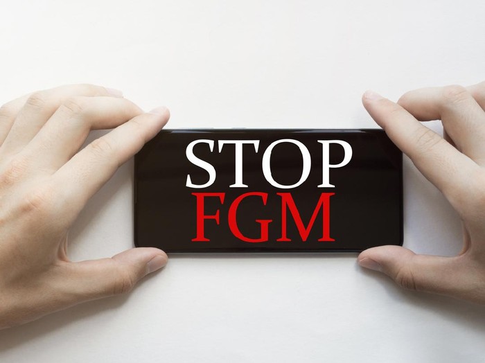 white paper with text Stop Fgm with clothespins on white background