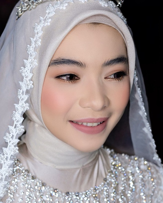 Inilah istri bintang Ikatan Cinta, Ikbal Fauzi Firdaus, Novia. Saat sesi prewedding, Novia menggunakan hijab katun shimmer yang dililit rapi ke belakang dan dilengkapi denggan inner bahan kaus. Hijab ini cocok digunakan di acara formal karena karakter bahannya yang berkilau namun tetap tegak di dahi ketika dipakai. Foto: Dok. Instagram @shariwedding.
