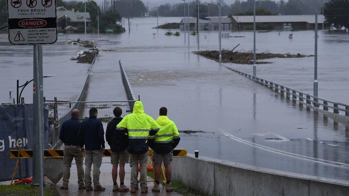 Potret Banjir Terburuk dalam 50 Tahun Terakhir di Australia People stand on the banks of the Nepean River at Jamisontown on the western outskirts of Sydney Monday, March 22, 2021. Australia's most populous state of New South Wales has issued more evacuation orders following the worst flooding in decades. (AP Photo/Mark Baker)