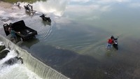 Warga memanfaatkan luapan Sungai Cileungsi untuk mencuci motor di Citeureup, Kabupaten Bogor, Jawa Barat, Senin (22/3/2021).