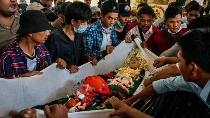 YANGON, MYANMAR - MARCH 21: (EDITORS NOTE: Image contains graphic content) Mourners prepare to carry the body of Aung Kaung Htet, 15, who was killed when military junta forces opened fire on anti-coup protesters, in a coffin during his funeral on March 21, 2021 in Yangon, Myanmar. Myanmars military Junta charged deposed de-facto leader Aung San Suu Kyi with accepting bribes and taking illegal payments in gold, as it also continued a brutal crackdown on a nationwide civil disobedience movement in which thousands of people have turned out in continued defiance of tear gas, rubber bullets and live ammunition. Over 180 people have been killed so far according to the U.N. (Photo by Stringer/Getty Images)