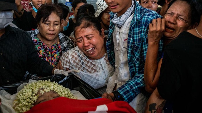 Jerit Tangis Keluarga Korban yang Ditembak Militer Myanmar YANGON, MYANMAR - MARCH 21: (EDITORS NOTE: Image contains graphic content) Mourners prepare to carry the body of Aung Kaung Htet, 15, who was killed when military junta forces opened fire on anti-coup protesters, in a coffin during his funeral on March 21, 2021 in Yangon, Myanmar. Myanmar's military Junta charged deposed de-facto leader Aung San Suu Kyi with accepting bribes and taking illegal payments in gold, as it also continued a brutal crackdown on a nationwide civil disobedience movement in which thousands of people have turned out in continued defiance of tear gas, rubber bullets and live ammunition. Over 180 people have been killed so far according to the U.N. (Photo by Stringer/Getty Images)