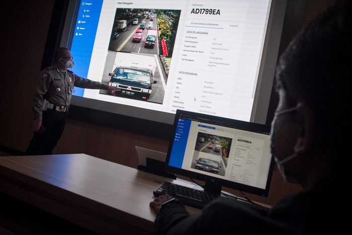 Polisi menunjukan rekaman kamera pengawas tilang elektronik atau Electronic Traffic Law Enforcement (ETLE) melalui layar monitor di Traffic Management Centre (TMC) Satlantas Polresta, Solo, Jawa Tengah, Jumat (19/3/2021). Polresta Solo akan memberlakukan tilang elektronik mulai 23 Maret 2021 dengan memasang kamera pengawas di sejumlah ruas jalan protokol dan kamera portabel yang terpasang di helm polantas. ANTARA FOTO/Mohammad Ayudha/wsj.