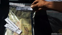 Barang bukti berupa beberapa lembar mata uang asing juga dipamerkan dalam rilis tersebut.