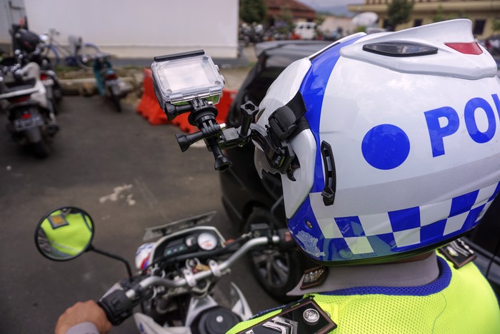 Polisi Lalu Lintas menggunakan helm yang dilengkapi kamera portabel pengawas tilang elektronik di Traffic Management Centre (TMC) Polres Pekalongan, Jawa Tengah, Selasa (23/3/2021). Polres Pekalongan menerapkan tilang elektronik atau Electronic Traffic Law Enforcement (ETLE) yang dilakukan serentak secara nasional dengan memasang kamera pengawas di empat titik di pusat kota dan pantura Kabupaten Pekalongan dan memasang kamera portabel yang terpasang di helm petugas polisi lalu lintas. ANTARA FOTO/Harviyan Perdana Putra/aww.