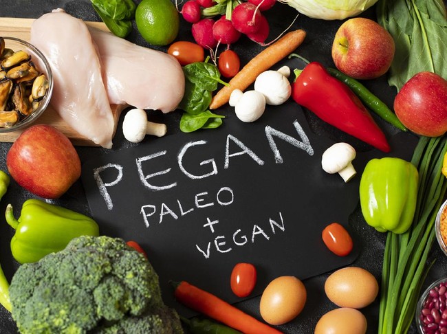 Pegan diet. Combination of vegan and paleo diets. Healthy food - assortment of fresh vegetables and fruits, chicken, eggs, mussels, legumes, mushrooms. Dark background