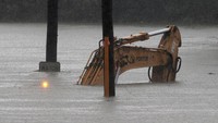 Tidak hanya mobil, traktor ikut terendam banjir. AP Photo/Rick Rycroft.