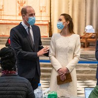 Kunjungan Pangeran William dan Kate Middleton ke pusat vaksinasi dadakan itu juga dalam rangka satu tahun Inggris memberlakukan lockdown pertama. Warna putih pada gaun Kate Middleton seakan juga menyimbolkan harapan baru untuk melewati masa-masa pandemi dengan adanya vaksin COVID-19. (Foto: Aaron Chown - WPA Pool/Getty Images)