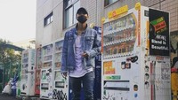 Pria yang jago nyanyi ini tak melewatkan pose di depan vending machine. Ia terlihat keren dengan outfit serba jeans. Foto: Instagram seo_cccc