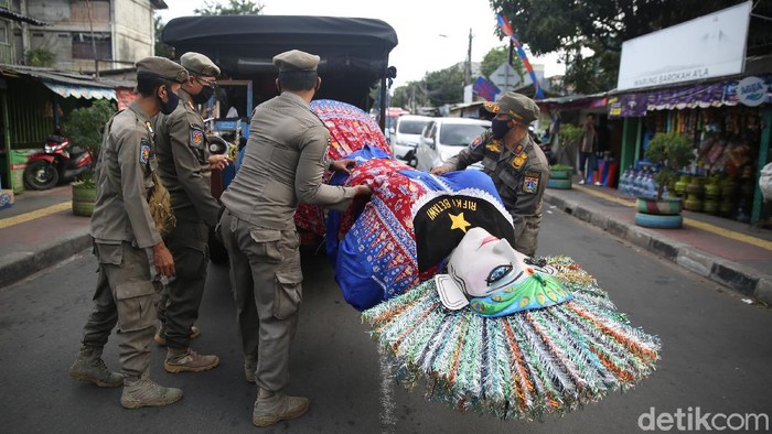 Petugas Satpol PP menangkap pengamen ondel-ondel di Buaran, Jakarta Timur, Rabu (24/3/2021).