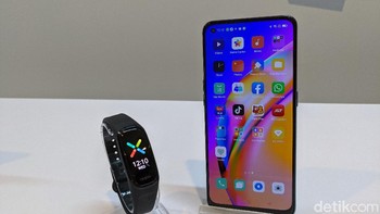 Oppo Band bersanding dengan Reno5 F. Gelang pintar ini memiliki rating 5ATM yang membuatnya tahan air hingga kedalaman 50 meter. Foto: Virgina Maulita Putri/detikINET