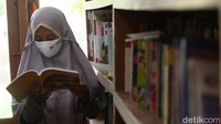 Seorang anak tengah membaca buku.