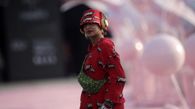 Sementara para model berjalan di antara mobil-mobil yang terparkir.