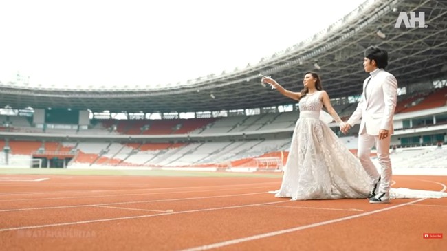 Momen di balik pemotretan tersebut terabadikan dalam sebuah video yang diunggah Atta di kanal YouTube-nya, Rabu (24/3/2021). Kemarin mau akad nggak bisa di sini, karena takut diprotes orang. Paling nggak sekarang kita bisa sewa untuk pre-wed, ujar Atta saat menumpangi buggy bersama Aurel menuju ke dalam area GBK.  (Foto: YouTube/Atta Halilintar)