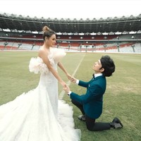 Atta pun mencoba bergaya classy dan elegan dengan setelan dengan jas berwarna midnight blue. Saat pemotretan, Atta berpose seolah-olah sedang melamar Aurel Hermansyah. Mau kah kamu menjadi ibu dari anak-anakku? tanya Atta dengan tatapan mesra di tengah hamparan lapangan hijau GBK yang megah itu. (Foto: YouTube/Atta Halilintar)