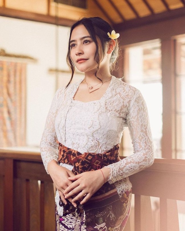 Prilly tampil memukau dalam balutan kebaya Bali lengan panjang berwarna putih. Kebaya tersebut dipadukan dengan kain bermotif berwarna ungu. Tak lupa penampilannya itu disempurnakan dengan selendang yang diikat seperti sabuk khas Bali. Foto: dok. Instagram/@prillylatuconsina96