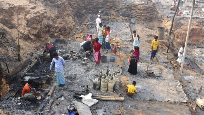 Puing-puing Kamp Rohingya Pasca Dilalap Api Rohingya refugees stand at the site of Monday's fire at a refugee camp in Balukhali, southern Bangladesh, Tuesday, March 23, 2021. Rescuers recovered more than a dozen charred bodies from a Rohingya refugee camp in southern Bangladesh after a devastating fire that destroyed thousands of shelters, officials said Tuesday. (AP Photo/ Shafiqur Rahman)