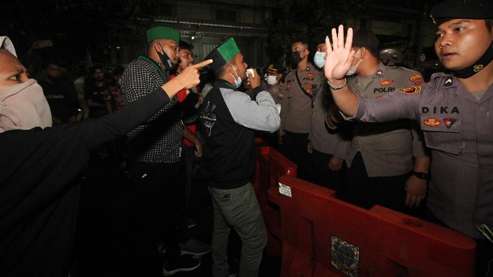 Massa Himpunan Mahasiswa Islam (HMI) berunjuk rasa di ruas Jalan Raya Dukuh Kupang saat berlangsungnya Kongres HMI XXXI di Islamic Center, Surabaya, Jawa Timur, Selasa (23/3/2021) malam. Massa yang bukan merupakan peserta tersebut memaksa untuk mendekat ke lokasi kongres namun demikian personel kepolisian menghadang mereka. ANTARA FOTO/Didik Suhartono/wsj.
