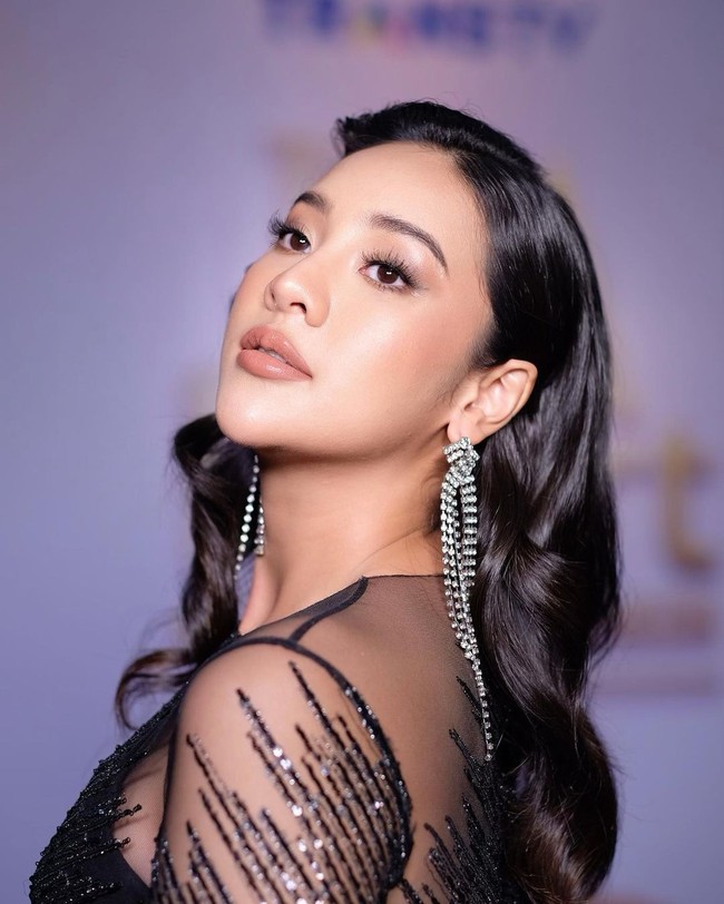 Gaun hitam berkilau yang dihiasi dengan payet dan sequin yang dikenakan oleh Anya itu merupakan rancangan Maison Bazz Couture. Bagaimana menurutmu penampilannya? Foto: Instagram/@leoafandi_makeup