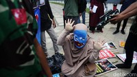 Massa juga melakukan aksi teatrikal. Aksi teatrikal itu melibatkan dua orang pria mengenakan baju loreng dengan satu wanita mengenakan baju muslimah.