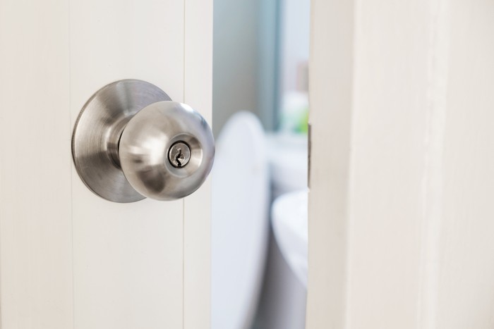 close up women twists doorknob to enter the bathroom