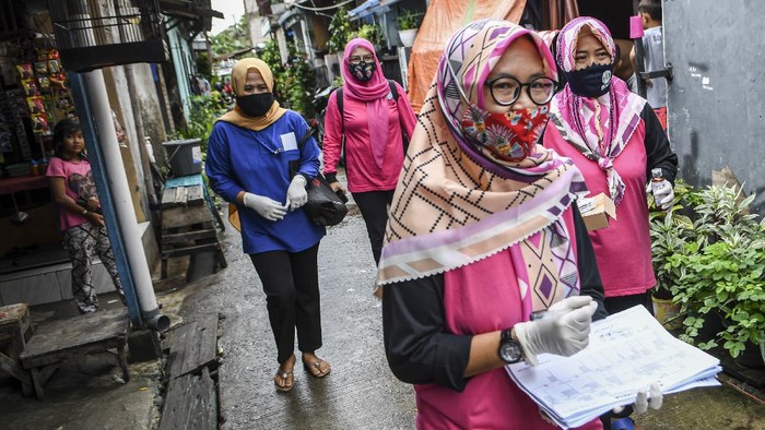 Jemput Bola Kader Posyandu di Tengah Pandemi Sejumlah kader posyandu berjalan menuju rumah warga di Rorotan, Jakarta Utara.