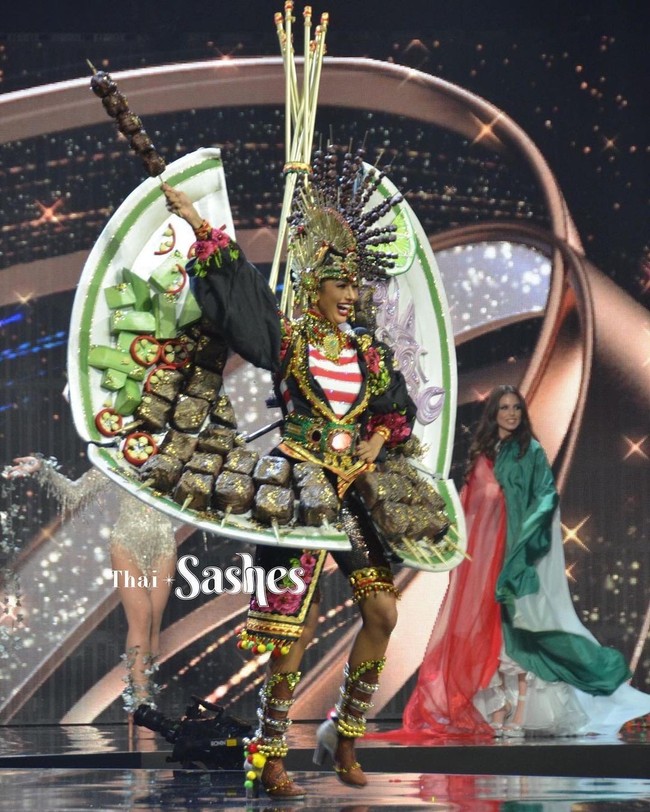 Kostum nasional yang dipakai Aurra Kharisma dibuat oleh Jember Fashion Carnaval. Kostum ini hadir dengan ornamen heboh yang berbentuk potongan daging yang ditusuk di atas piring dengan acar sebagai pendamping.  (Foto: Instagram/@thaisashes)