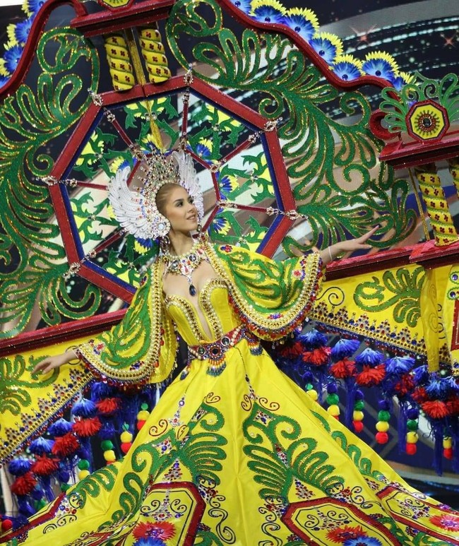 Kostum yang didominasi warna kuning dan hijau ini dikenakan oleh Miss Grand Guatemala, Ivana Batchelor. Warna-warna dari kostum karya Cesar Alejandro Portillo itu melambangkan kota di Xecul, Guatemala. Dengan berbagai macam aksen dan warna yang cerah, penampilan Ivana terlihat menawan. Foto: Instagram/@officialglobalbeauties