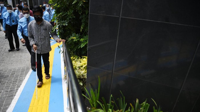 PENGADILAN JAKARTA PUSAT SEDIAKAN FASILITAS BAGI DISABILITAS Penyandang tunanetra didampingi petugas berjalan di jalur pemandu di PN Jakarta Pusat, Jakarta, Kamis (25/3/2021). PN Jakarta Pusat memfasilitasi sarana dan prasarana bagi penyandang disabilitas untuk memberikan pelayanan peradilan kepada seluruh lapisan masyarakat. ANTARA FOTO/Hafidz Mubarak A/wsj.