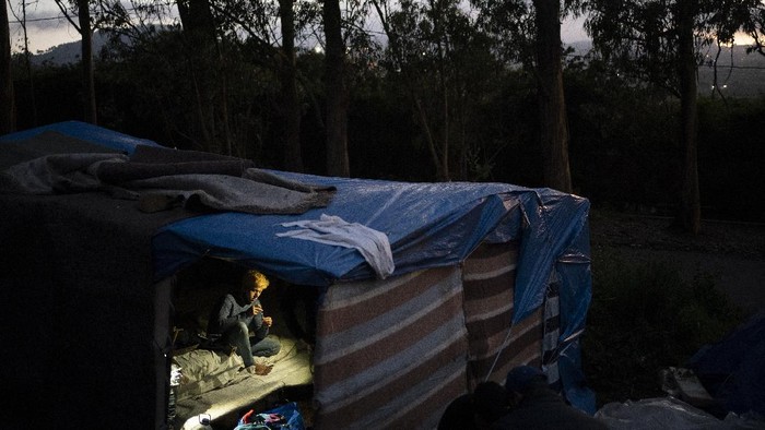 A migrant receives donated food outside Las Raices camp in San Cristobal de la Laguna, in the Canary Island of Tenerife, Spain, Saturday, March 20, 2021. While Spain has been critical of its European neighbours' lack of solidarity when it comes to sharing the responsibility of migration, the country is similarly being criticized by migrants, authorities and human rights organizations on the Canary Islands where some 23,000 people arrived by sea last year and where many thousands remain on the island forcefully. (AP Photo/Joan Mateu)