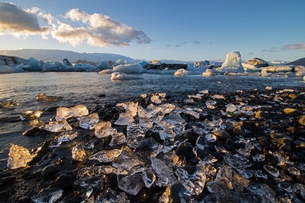 Bebatuan bening ini adalah patahan gletser yang tersapu dari laut ke pinggir pantai.
