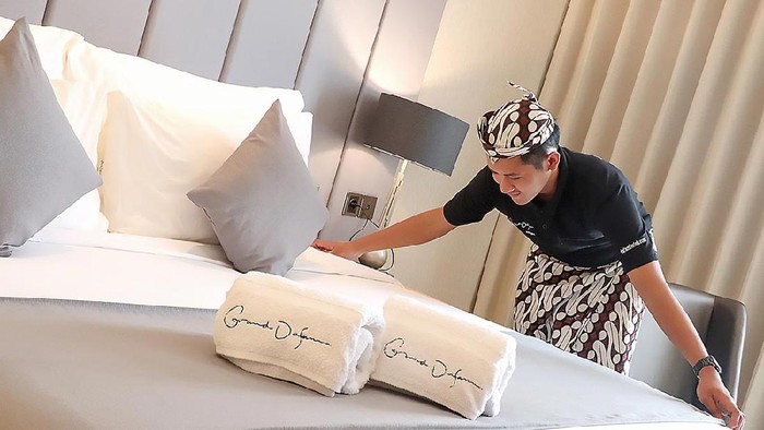 Karyawan Grand Dafam Signature membereskan kamar hotel di Surabaya.