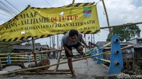 Seorang warga beraktivitas di sekitar jembatan Graha Prima-Kali Jambe yang rusak dan ditutup untuk sementara di kawasan Tambun Selatan, Kabupaten Bekasi, Jumat (26/3/2021).
