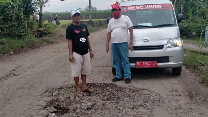 Sebuah spanduk bertuliskan Selamat Datang ke Kampung Wisata Jeglongan Sewu terpasang di jalan. Spanduk itu bentuk kegeraman warga karena laporan mereka soal kerusakan jalan tak mendapat tanggapan dari pemerintah.