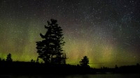 Aurora muncul di tengah gugusan bintang yang tersebar di langit.