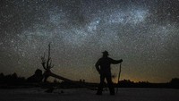 Seorang warga mengamati Bima Sakti yang tampak di atas cagar alam Ontario, Kanada.