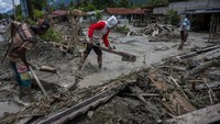 Sejumlah relawan dan anggota TNI membersihkan sisa lumpur yang menerjang permukiman di Desa Beka, Marawola, Kabupaten Sigi, Sulawesi Tengah, Sabtu (27/3/2021). 