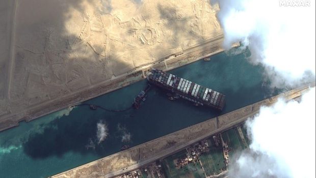 This satellite image from Maxar Technologies shows the cargo ship MV Ever Given stuck in the Suez Canal near Suez, Egypt, Friday, March 26, 2021. A maritime traffic jam grew to more than 200 vessels Friday outside the Suez Canal and some vessels began changing course as dredgers worked frantically to free a giant container ship that is stuck sideways in the waterway and disrupting global shipping. (©Maxar Technologies via AP)