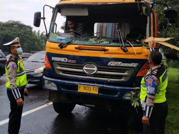 Pohon tumbang di Tol Waru KM 10.200/B arah Perak, usai diguyur hujan deras disertai angin kencang. Pohon itu menimpa 2 kendaraan.