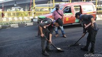 Sejumlah pekerja dikerahkan untuk menyelesaikan proses pengaspalan jalan tersebut. 