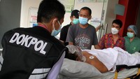 Personel Dokpol Polda Sulawesi Selatan membawa korban ledakan bom ke dalam mobil ambulans untuk dirujuk ke Rumah Sakit Bhayangkara di Makassar, Sulawesi Selatan, Minggu (28/3/2021).