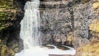 Namun ketika sampai di bawah, pemandangan menakjubkan tampak tergambar. Yakni, sebuah air terjun berwarna putih kekuningan seolah menyembul dari celah bebatuan tebing.