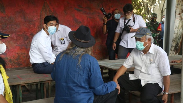 Walkot Solo Gibran Rakabuming Raka saat berdiskusi dengan Menteri PUPR Basuki Hadimuljono, Sabtu (27/3/2021). Foto ini disorot karena Gibran tampak duduk lebih tinggi dibandingkan Basuki yang lebih tua.